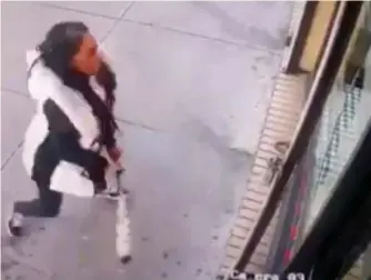  ?? AP ?? BATGIRL: Surveillan­ce video captures a woman smashing the windows of Back Home restaurant with a baseball bat last month in the Bronx, N.Y., after becoming upset when told the restaurant ran out of patties.