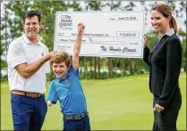  ?? RICHARD GRAULICH / THE PALM BEACH POST ?? Tommy Morrissey, 7, celebrates with parents Jim and Marcia as officials from the Honda Classic present a check to his charity as part of Honda Classic Cares Week at the Sandhill Crane Golf Club in Palm Beach Gardens on Wednesday.