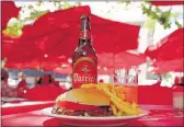  ??  ?? Enjoy a chivito, a popular steak sandwich, alongside a Patricia, a local beer. Uruguayans eat as late as 11 p.m., but some restaurant­s serve as early as 8 p.m.