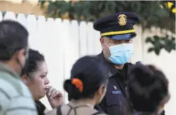  ?? Yalonda M. James / The Chronicle ?? Police Lt. Eric Lewis speaks with relatives after a fatal shooting Oct. 14 on 84th Avenue. Oakland has already topped 100 homicides this year.