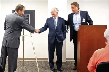  ?? Kaitlyn Rigdon,News-TImes ?? Vision to reality: Above, left, Rob Robinson, chairman of MCSA’s board, shakes Dr. Robert Tommey’s hand after MCSA’s CEO Scott Street, far right, announced the new conference center was being named after Tommey. A ceremony was held Thursday in the conference center, where it was announced as the “Robert C. Tommey Conference Center.” Below, MCSA General surgeon Dr. Robert Tommey stands next to a plaque naming the hospital’s new conference center