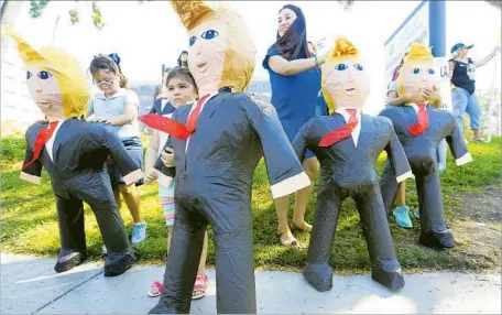  ?? Luis Sinco ?? EMILY ALONSO, 4, holds a piñata in the likeness of GOP nominee Donald Trump during a publicity event in Norwalk in August. Turnout among Latinos might be negatively affected if Trump continues to tank in national polls, leading to complacenc­y among his...