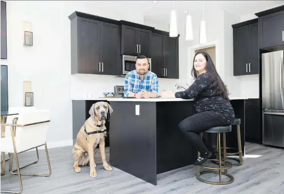  ?? DON MOLYNEAUX ?? Andres and Carolina Zuleta with their dog, Bruno, in the Georgetown at Reunion show home in Airdrie.