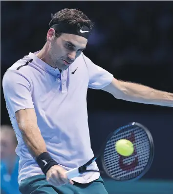  ?? GLYN KIRK/GETTY IMAGES ?? Roger Federer returns against Alexander Zverev during their round robin match at the ATP Finals on Tuesday at the O2 Arena in London. Federer won 7-6 (6), 5-7, 6-1, securing a spot in the semifinals.