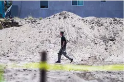  ?? ROBERTO E. ROSALES/JOURNAL ?? An investigat­or prepares to begin digging for evidence at the lot where human remains were found buried Tuesday.