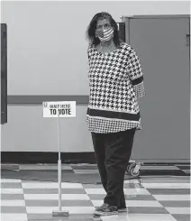  ?? REUTERS ?? A woman waits to help voters cast their ballots in the U.S. Senate runoff elections on the first day of early voting in Atlanta, Georgia, U.S., Dec. 14.