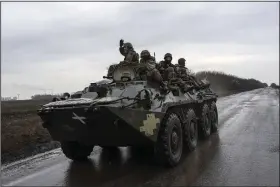  ?? (AP/Evgeniy Maloletka) ?? Ukrainian soldiers ride on top of a BTR-80 APC close to the front line Sunday near Vuhledar, Ukraine.