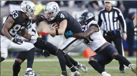  ?? BOB SELF/TRIBUNE NEWS SERVICE ?? The Raiders' Derek Carr takes a sack from the Jaguars defense during Sunday's loss.