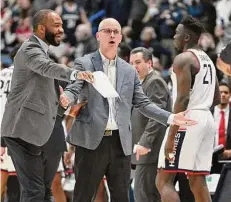  ?? Jessica Hill / Associated Press ?? UConn coach Dan Hurley, center, reacts with associate coach Kimani Young in the first half against St. John’s on Jan. 15.