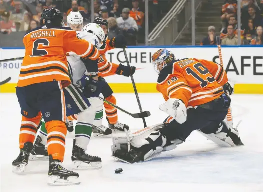  ?? CODIE MCLACHLAN/GETTY IMAGES ?? Oilers goaltender Mikko Koskinen makes a save Friday night against the Canucks' Matthew Highmore at Rogers Place. The Oilers won it 3-2 in a shootout.