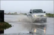  ?? ?? A truck drives through a flooded section of Ocean View Boulevard in Pacific Grove on Friday.