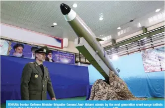  ?? — AFP ?? TEHRAN: Iranian Defense Minister Brigadier General Amir Hatami stands by the next generation short-range ballistic missile “Fateh Mobin” during an unveiling ceremony in the capital yesterday.