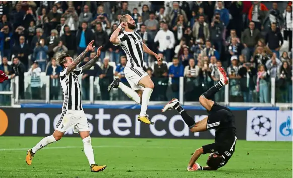  ?? — Reuters ?? Top of the world: Gonzalo Higuain taking flight after Juventus’ win over Olympiakos in Turin.