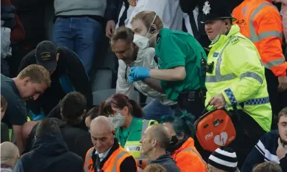  ?? ?? A policeman holds a defibrilla­tor brought by the Newcastle team doctor during the medical emergency which stopped play. Photograph: Tom Jenkins/The Guardian