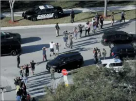  ?? MIKE STOCKER — SOUTH FLORIDA SUN-SENTINEL VIA AP ?? In this file photo, students hold their hands in the air as they are evacuated by police from Marjory Stoneman Douglas High School in Parkland, Fla., after a shooter opened fire on the campus.