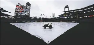  ?? MATT SLOCUM/AP ?? A TARP IS SEEN COVERING THE FIELD as a storm postpones a game between the Philadelph­ia Phillies and the New York Mets on Saturday in Philadelph­ia.