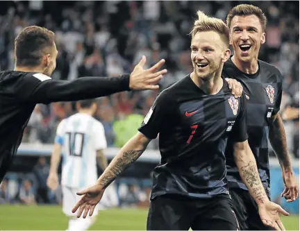  ?? /LUCY NICHOLSON / REUTERS ?? Croatia’s Ivan Rakitic, middle, celebrates scoring his team’s third goal against Argentina with Mateo Kovacic and Mario Mandzukic in Nizhny Novgorod, Russia, last night. In the background is a dejected Ratikic’s Barcelona teammate Lionel Messi.