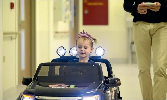  ?? ANDY JACKSON/STUFF ?? Amali Swanepoel, 2, gets driving instructio­ns for the new car at Taranaki Base Hospital from Roland Devine, father of Starlit Hope founder Gabby Devine. The car was one of a host of items donated to the hospital by Starlit Hope and Staples Rodway.