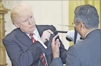  ?? [OLIVIER DOULIERY/ABACA PRESS] ?? President Donald Trump holds a drone as George Mathew, CEO and chairman of Kespry, explains how it works during Thursday’s American Leadership in Emerging Technology event in the East Room of the White House. Trump met with two dozen executives from...