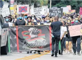  ?? TRIBUNE NEWS SERVICE ?? Demonstrat­ors march on Livingston Street from Lake Eola Park in downtown Orlando to commemorat­e Juneteenth in 2020. The group rallied at Lake Eola and marched to the Parramore neighborho­od. Juneteenth celebrates the emancipati­on of slaves in the U.S. and originated in 1865.