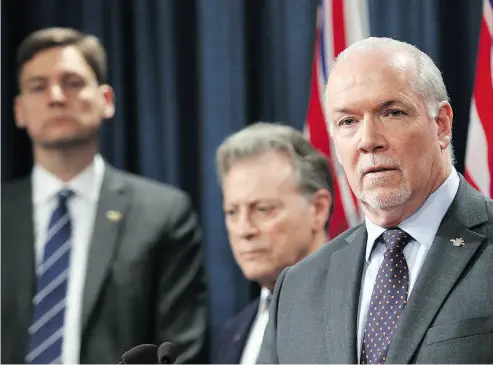  ?? CHAD HIPOLITO / THE CANADIAN PRESS ?? B.C.’s Premier John Horgan, right, along with Attorney General David Eby and Environmen­t Minister George Heyman, meet with media on Thursday to discuss the B.C.’s filing of a court case over oil jurisdicti­on in the province.