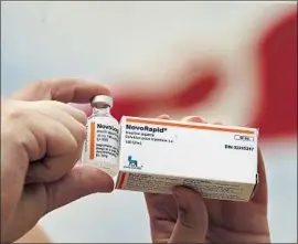  ?? Canadian Press ?? ALLISON NIMLOS of Minnesota holds a vial of insulin she got in the U.S. along with insulin that she bought in Ontario, Canada, for a fraction of the price.