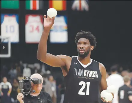  ?? AP PHOTO ?? Team Africa’s Joel Embiid throws balls to fans Aug. 4 during the NBA Africa Game between Team Africa and Team World at the Sun Arena in Pretoria, South Africa. The NBA has big plans for Africa where an office was establishe­d eight years ago in South Africa and there’s an annual exhibition game featuring NBA stars.