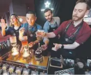  ?? Elaine Thompson, The Associated Press ?? Baristas from Starbucks’ specialize­d coffee shop, Reserve Roastery, demonstrat­e a siphon brew of individual cups before the company’s shareholde­rs meeting last year.