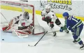  ??  ?? Moose Jaw Warriors goaltender Brody Willms turns aside a shot by Swift Current’s Beck Malenstyn as Jett Woo covers the play.