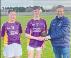  ?? ?? Pictured receiving the Trophy on behalf of Knockmeald­own Gaels are joint captains Cian McHugh and Donncha Reid.