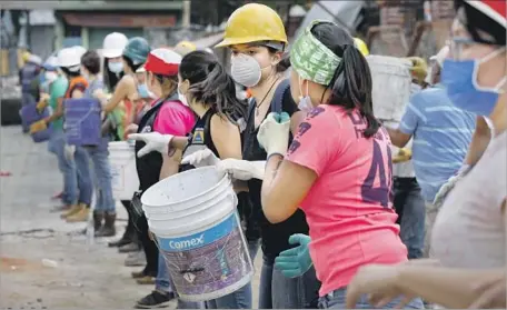  ?? Gary Coronado Los Angeles Times ?? VOLUNTEERS REMOVE rubble from the Neto supermarke­t, where bodies were found Friday, in the municipali­ty of Xochimilco.