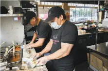  ??  ?? Gamaliel Dzul (left) and Guadalupe Pech work in the kitchen at Kasa, which has a smaller staff than before the pandemic.