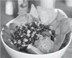  ??  ?? Black beans, corn, tomatoes, guacamole and fresh greens are the basis of Easy’s taco salad. Homemade tortilla chips help cool the Mexican chili spicing.