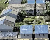  ?? WILFREDO LEE AP File ?? Homeowners cover their roofs in blue tarps after damage caused by Hurricane Wilma in Broward County on Oct. 26, 2005.