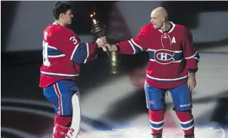  ?? JOHN KENNEY/MONTREAL GAZETTE ?? Veteran defenceman Andrei Markov hands the torch to goalie Carey Price moments after having a bit of fun at defenceman P.K. Subban’s expense.