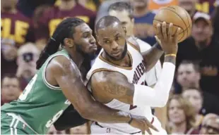  ?? AP ?? LeBron James, de los Cavaliers de Cleveland, protege el balón ante la defensa de Jae Crowder, de los Celtics, durante el partido del domingo por la noche.