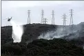  ?? JEFF CHIU / AP FILE ?? In this 2019 photo, a helicopter drops water near power lines and electrical towers while working at a fire on San Bruno Mountain near Brisbane.
