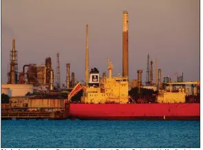  ?? (Bloomberg News) ?? A tanker is moored near an Exxon Mobil Corp. refinery in Fawley, England, in this May file photo.