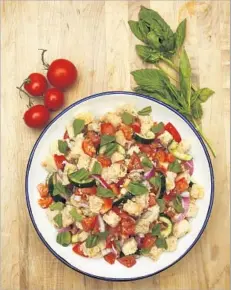  ?? Anne Cusack Los Angeles Times ?? PANZANELLA, a Tuscan summer salad, is a cinch with stale bread and ripe tomatoes. Combine with cucumbers, onions and a vinaigrett­e.