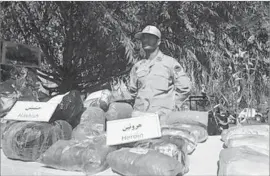  ?? Vahid Salemi Associated Press ?? AN IRANIAN officer displays seized drugs in 2014. Iran is on the main traffickin­g route for poppy, the source of opium and heroin, from Afghanista­n to Europe.