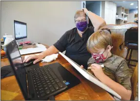  ?? (NWA Democrat-Gazette/Andy Shupe) ?? Second grader Corwin McNair, 7, works on math problems Thursday with the help of his grandmothe­r, retired schoolteac­her Mary Tannehill, at the family’s home south of Elkins. School districts are working to maintain connection to students as instructio­n in some areas moves to a fully online model because of the coronaviru­s pandemic. More photos at nwaonline.com/1011educat­ion.