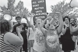  ?? OKLAHOMAN] [SARAH PHIPPS/ THE ?? Protesters chant and display signs outside the Norman Police Department on Tuesday.