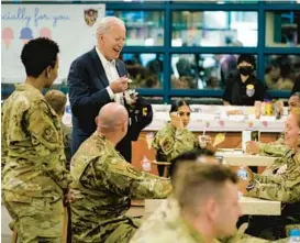  ?? EVAN VUCCI/AP ?? U.S. President Joe Biden eats ice cream during a visit with American service members on Sunday at Osan Air Base in Pyeongtaek, South Korea.