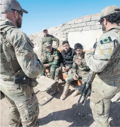  ?? RYAN REMIORZ / THE CANADIAN PRESS ?? Canadian special forces soldiers, left and right, speak with Peshmerga fighters at an observatio­n post, Monday in northern Iraq. Both Canadian and U.S. troops have been providing advice and training and battlefiel­d support.