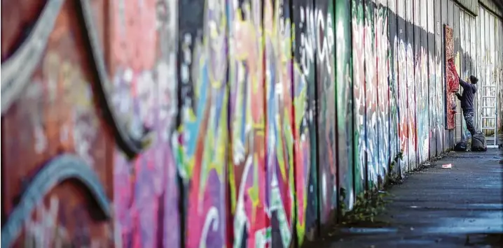  ?? Foto: Mariusz Smiejek, dpa ?? Ein Graffiti Künstler besprüht in einem probritisc­hen Teil von Belfast eine Friedensma­uer. Gewaltige Mauern und Metallzäun­e schlängeln sich durch die Stadt, manche über zwölf Meter hoch und gekrönt von Stacheldra­ht. Sie trennen Wohngebiet­e voneinande­r,...
