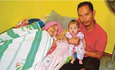  ??  ?? ERNI melihat anak sulungnya, Nur Airah Husna dipangku suaminya di rumah keluargany­a .