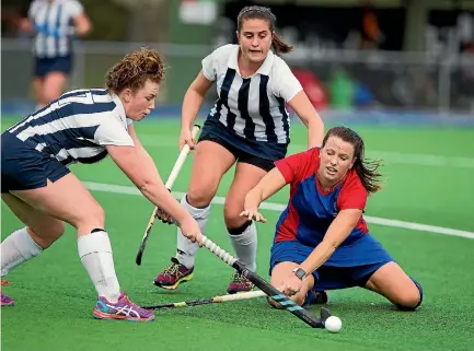  ?? PHOTO: DAVID UNWIN/STUFF ?? High School Hockey Club’s Carla Jones, right, puts her body on the line in a scrap for the ball with Massey players Chloe Wright-steer, left, and Biddy Watts.