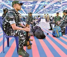  ?? ?? All set: (From top right) O icials on election duty collected EVMs, VVPAT units, and other materials before heading to their respective polling booths and CRPF personnel waiting to accompany the o icials, on a school campus at Rajarajesh­warinagar in Bengaluru on Thursday.