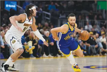  ?? Associated Press ?? On the move: Golden State Warriors guard Stephen Curry, right, moves the ball while defended by Denver Nuggets forward Aaron Gordon during the second half of an NBA basketball game Sunday in San Francisco.