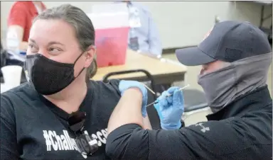  ?? Keith Bryant/The Weekly Vista ?? Liz Srader (left) receives her covid-19 vaccine, injected by firefighte­r engineer Chaz Harmon at a clinic the Bella Vista Fire Department hosted last week, at which firefighte­rs inoculated more than 1,300 people.